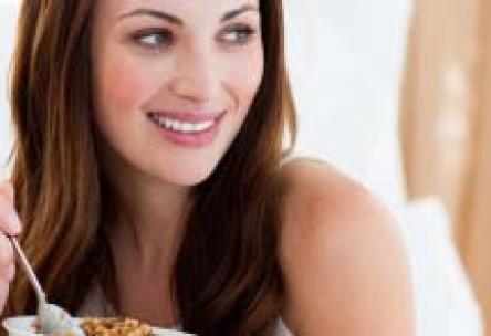 Photo: Smiling woman with bowl of cereal